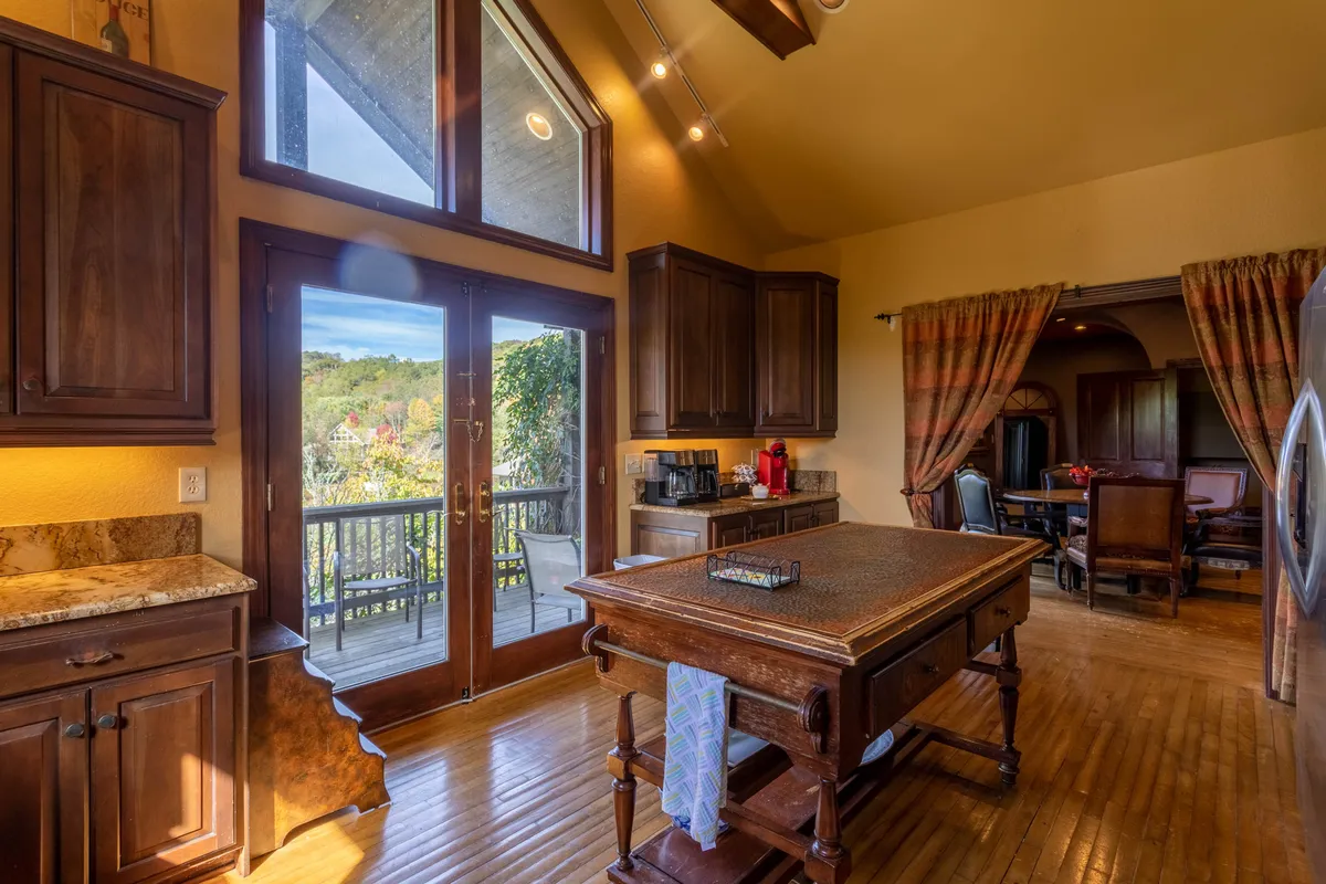 A spacious, open-concept kitchen and dining area with a central kitchen island, large windows bringing in natural light, and an adjacent dining table. The space is optimized for entertaining, with modern appliances, ample seating, and scenic views. The transitions between kitchen and dining area are smooth, supporting seamless group interaction.